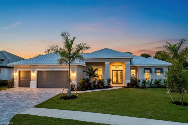 View of front of home with a front lawn, decorative driveway, stucco siding, and an attached garage
