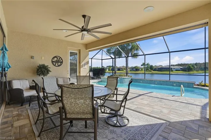 View of patio with a sunroom, an outdoor pool, a ceiling fan, and glass enclosure