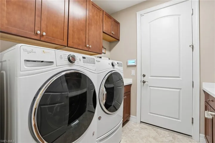 Laundry area with independent washer and dryer and cabinet space