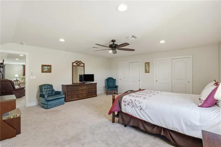 Upstairs Bedroom featuring light colored carpet, multiple closets, recessed lighting, and ceiling fan