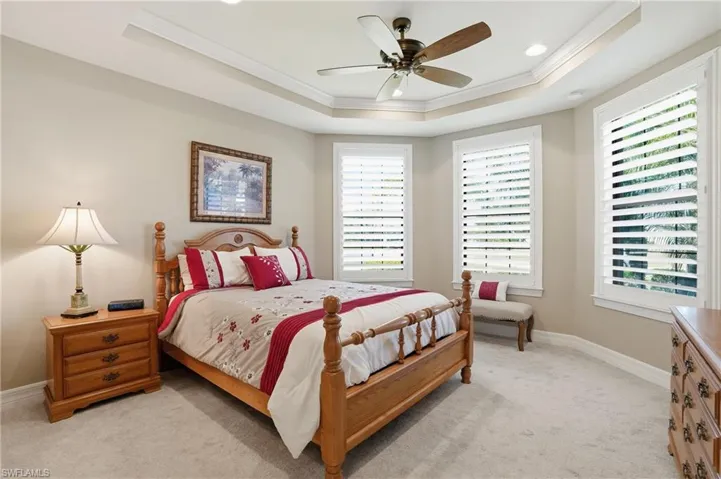 Bedroom featuring crown molding, ceiling fan, light colored carpet, a tray ceiling, and recessed lighting