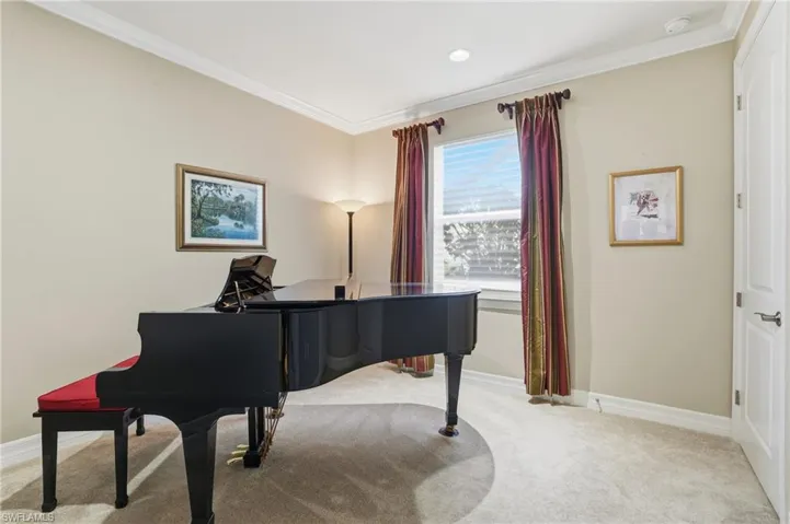 Bedroom with ornamental molding and light carpet