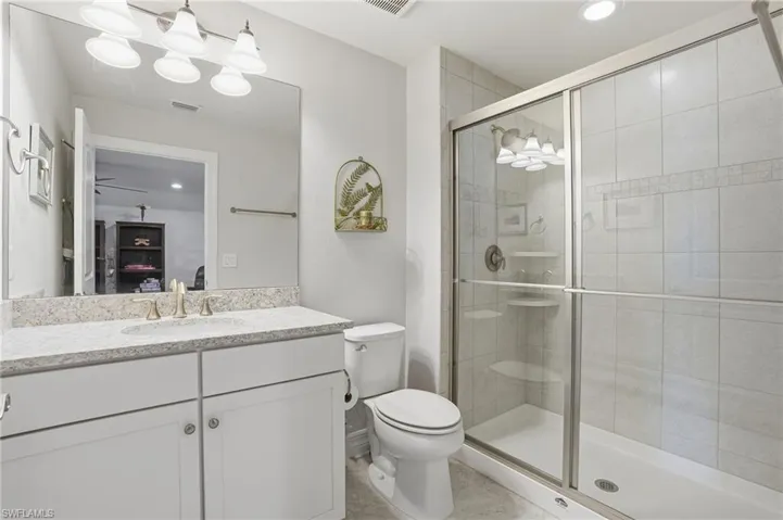 Full bathroom with vanity, a shower stall, and recessed lighting