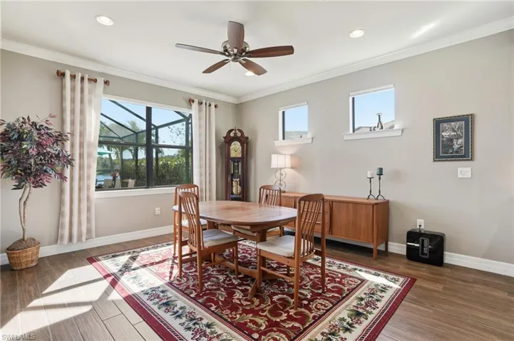 Dining area featuring ornamental molding, plenty of natural light, ceiling fan, dark wood-style flooring, and recessed lighting