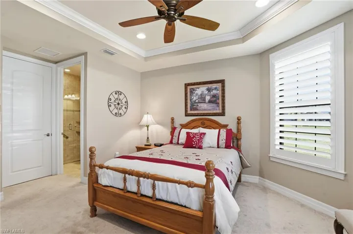 Bedroom with carpet flooring, crown molding, a ceiling fan, a tray ceiling, and recessed lighting
