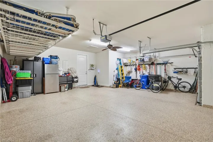 Garage featuring freestanding refrigerator and a garage door opener