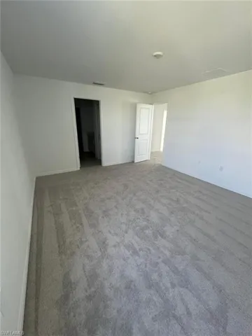 Carpeted empty room featuring baseboards