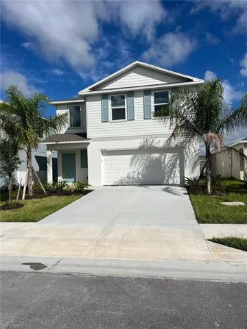 View of front facade with driveway, an attached garage, and stucco siding