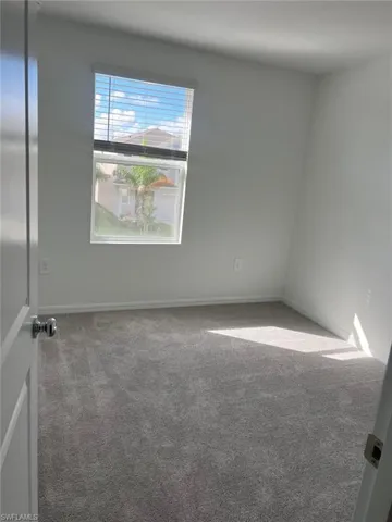 Empty room featuring carpet flooring and baseboards