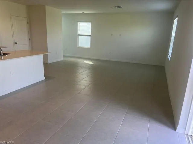 Empty room featuring baseboards and light tile patterned flooring