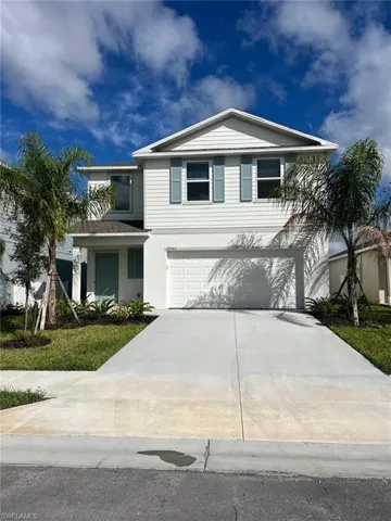 View of front of property featuring concrete driveway, stucco siding, and an attached garage