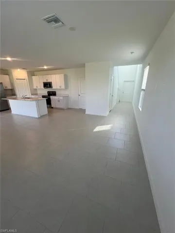 Unfurnished living room with baseboards and light tile patterned floors