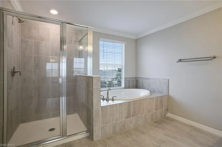 Bathroom featuring tile patterned floors, ornamental molding, and independent shower and bath