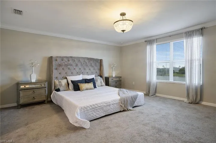 Carpeted bedroom with ornamental molding