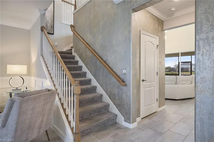 Stairs featuring tile patterned flooring and ornamental molding
