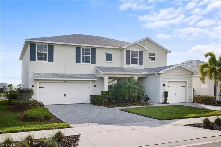 View of front of property featuring a garage and a front lawn