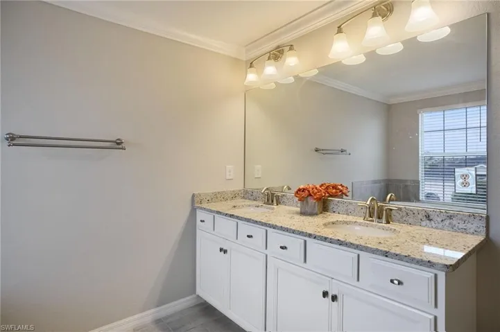 Bathroom featuring vanity, crown molding, and tile patterned flooring