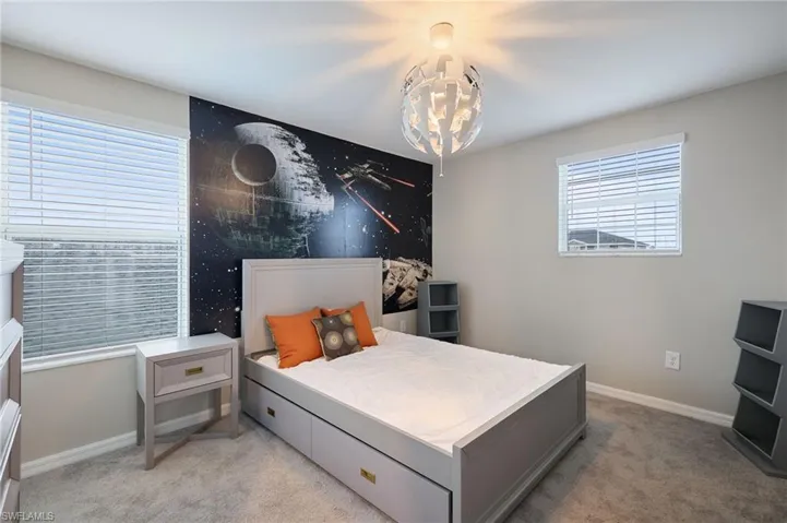 Carpeted bedroom with a chandelier