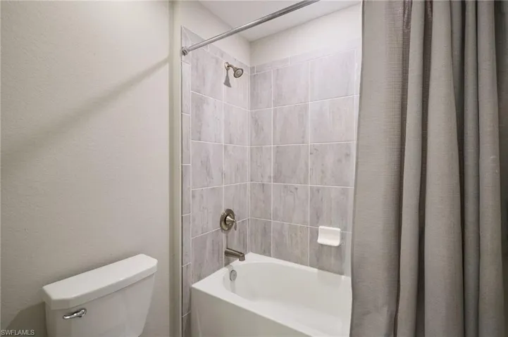 Bathroom featuring shower / bath combo with shower curtain and toilet
