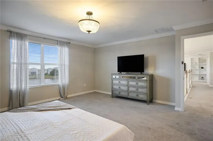 Bedroom featuring ornamental molding and light carpet