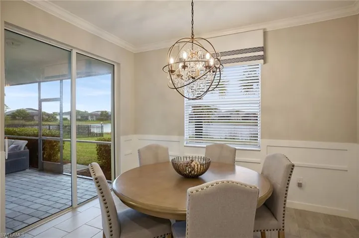 Dining space with a chandelier and crown molding