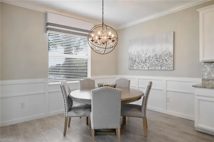 Dining room with an inviting chandelier and ornamental molding