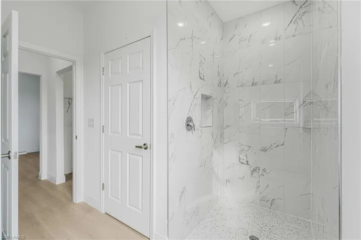 Bathroom featuring a tile shower and hardwood / wood-style flooring