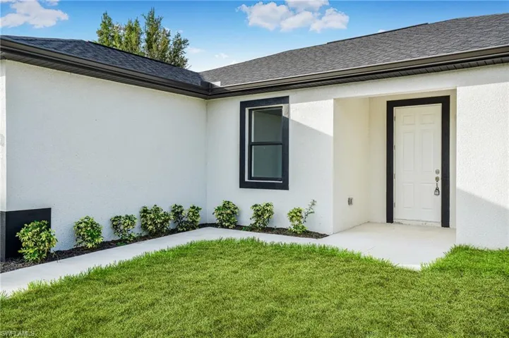 View of exterior entry featuring a yard