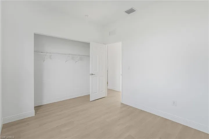 Unfurnished bedroom featuring light hardwood / wood-style flooring and a closet