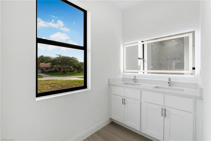 Bathroom featuring vanity, hardwood / wood-style flooring, and a wealth of natural light