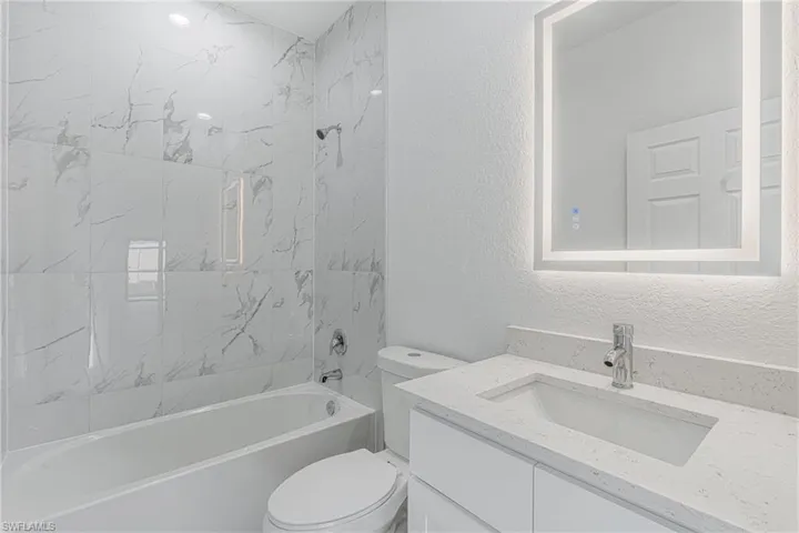 Full bathroom featuring vanity, toilet, and tiled shower / bath