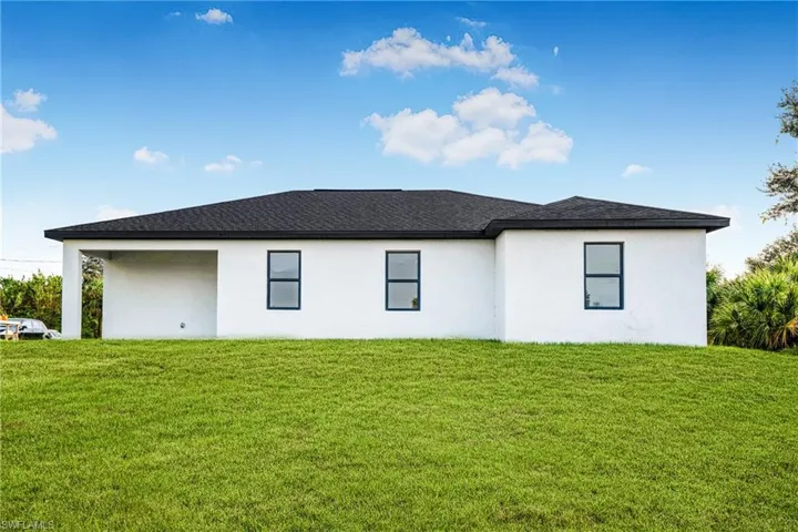 Rear view of house with a yard