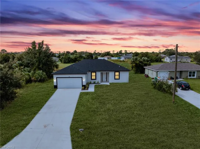View of front of property featuring a garage and a lawn