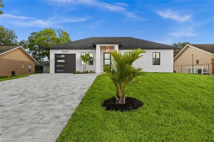 Modern single-story residence with a white stucco facade and dark gray roof