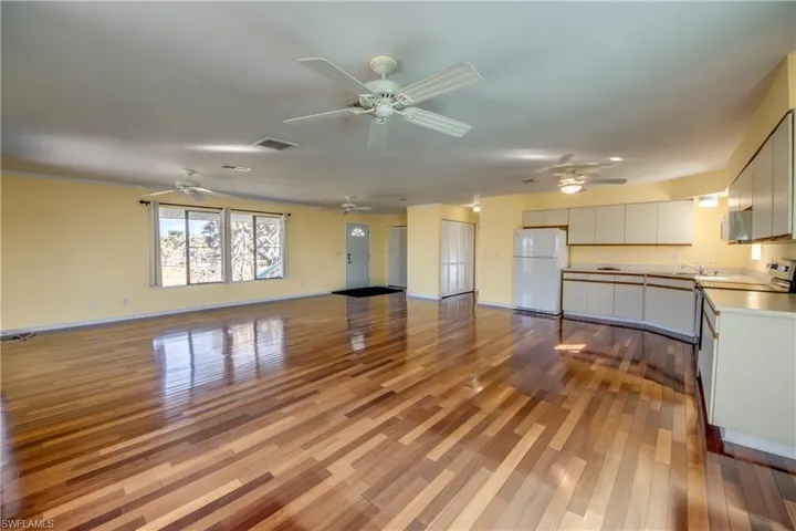 Unfurnished living room featuring ceiling fan and light hardwood / wood-style flooring