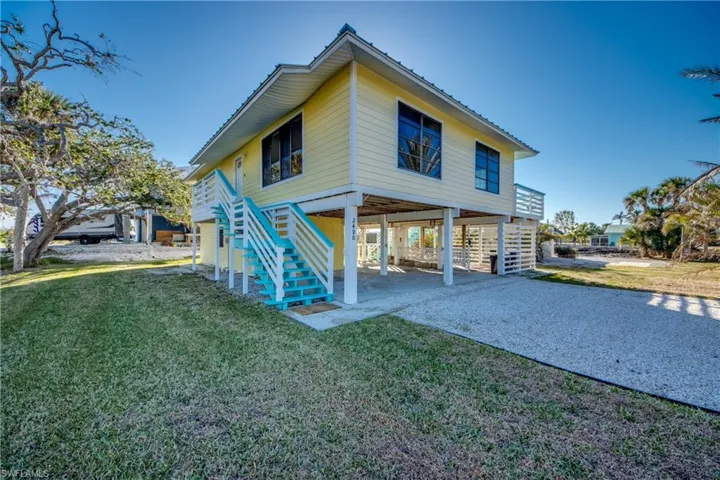 Rear view of house with a lawn and a carport