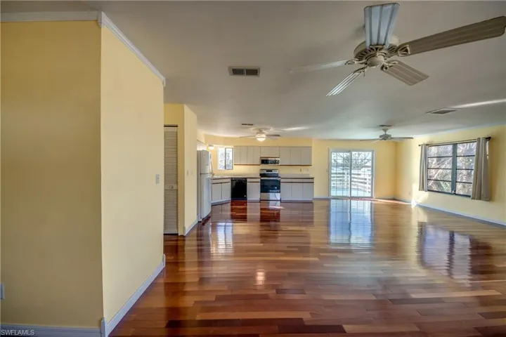 Unfurnished living room featuring crown molding and dark hardwood / wood-style floors