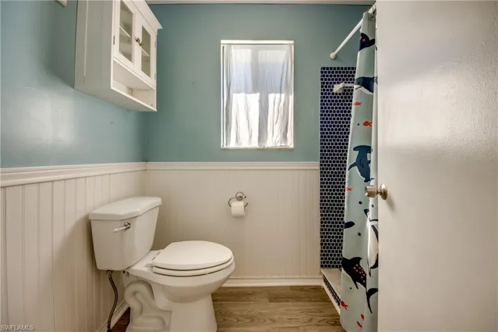 Bathroom featuring toilet, wood-type flooring, a baseboard radiator, and walk in shower
