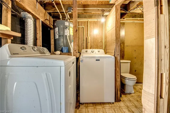 Laundry room featuring independent washer and dryer and water heater