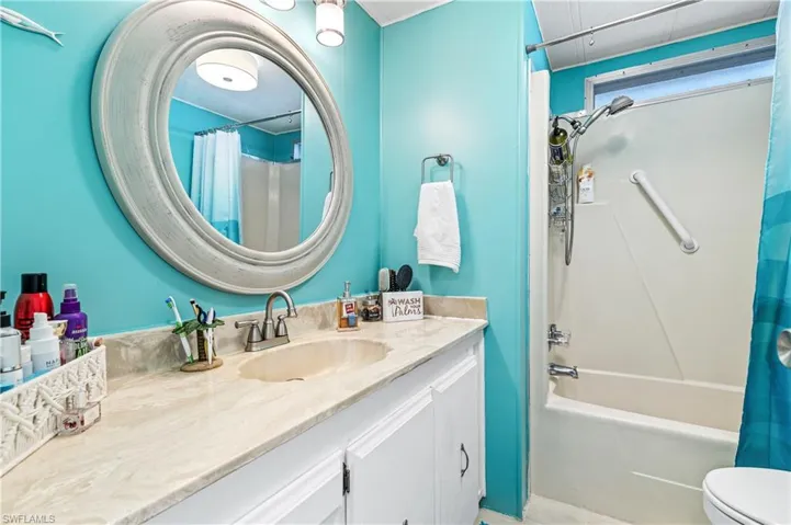 Bathroom featuring shower / bath combination with curtain and vanity
