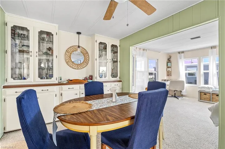 Dining space featuring light colored carpet and ceiling fan