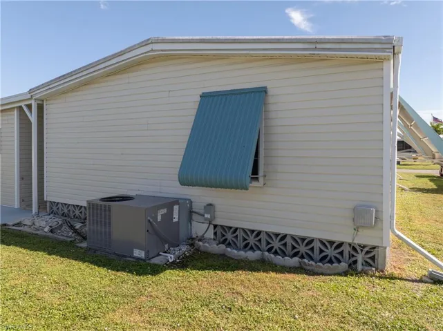 View of home's exterior with a central AC unit and a yard