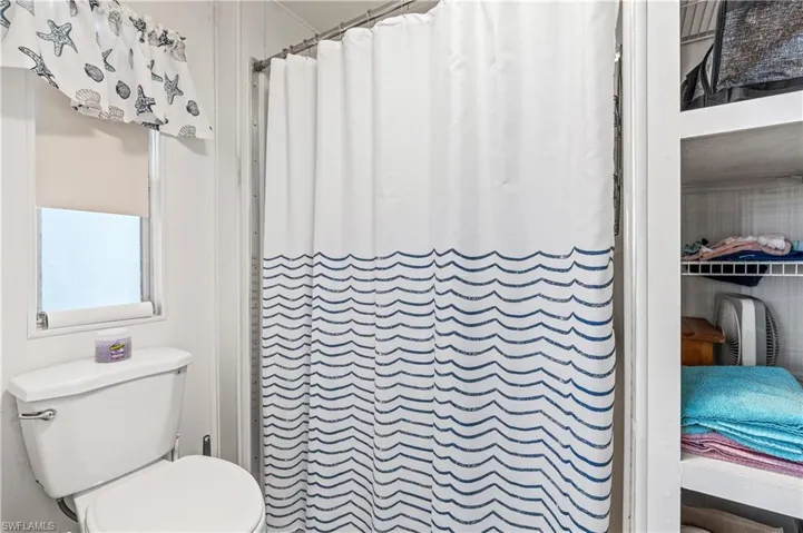 Full bathroom with curtained shower and toilet