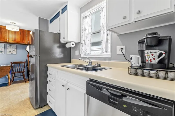 Kitchen with appliances with stainless steel finishes, light countertops, and white cabinetry
