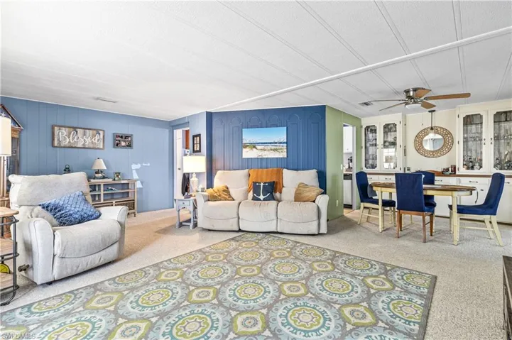 Carpeted living room featuring a ceiling fan