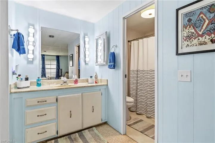 Bathroom with a shower with shower curtain and vanity