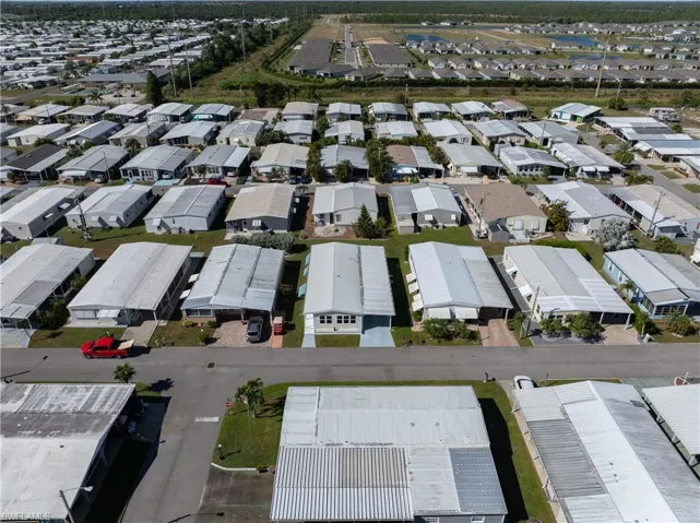Aerial view of property and surrounding area featuring nearby suburban area