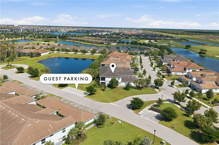 Aerial perspective featuring designated guest parking, multi-unit residential architecture, and water frontage