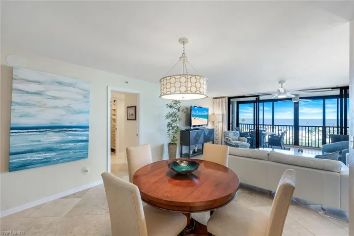 Dining area featuring a ceiling fan, light tile patterned floors, and expansive windows