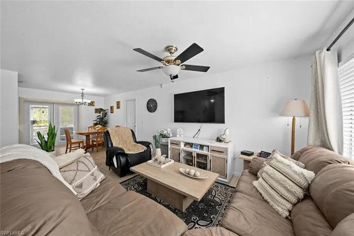 Living room featuring a chandelier, a ceiling fan, and tile patterned flooring